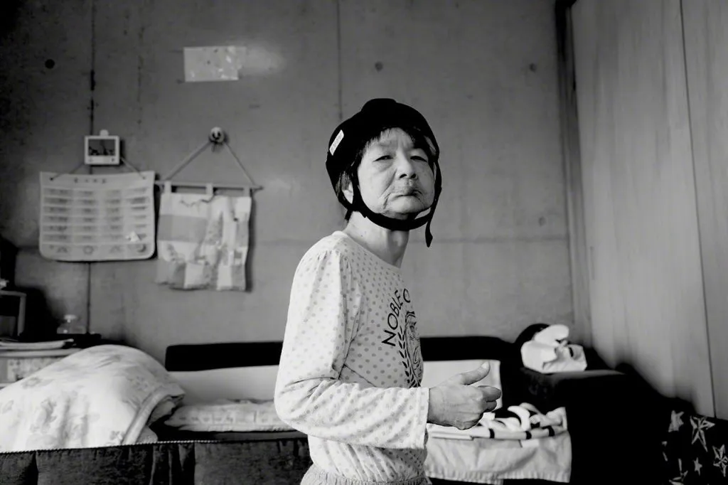 Tanaka Jitsuko nel 2018. Oggi risiede con la sorella anziana e il cognato e riceve assistenza infermieristica 24 ore su 24. Il casco serve a proteggere la sua testa dalle cadute