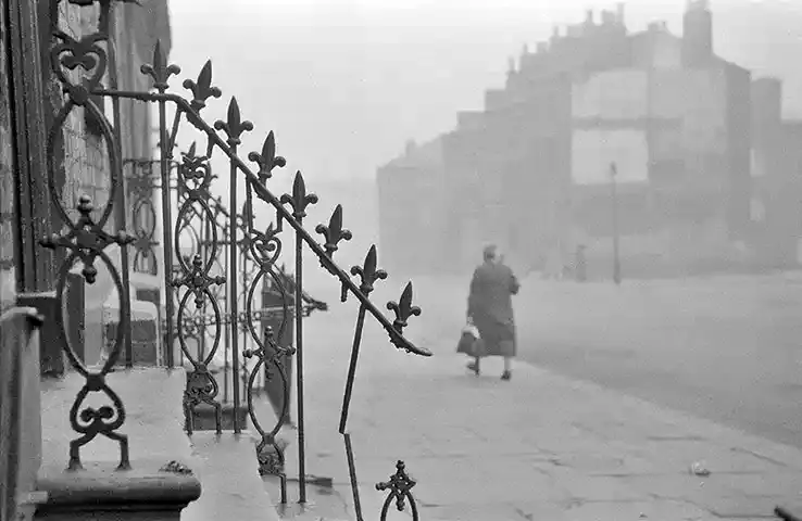 170.Thurston Hopkins - Lo sguardo umano della fotografia britannica 34 33.Liverpool Slums reportage1956 una donna che passeggia in una baraccopoli di Liverpool.Thurston Hopkins