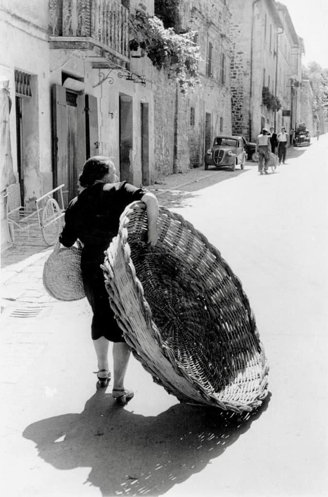 170.Thurston Hopkins - Lo sguardo umano della fotografia britannica 37 36.Una donna trasporta un grande cesto di vimini per una strada di Assisi. Italia anni 50.Thurston Hopkins foto