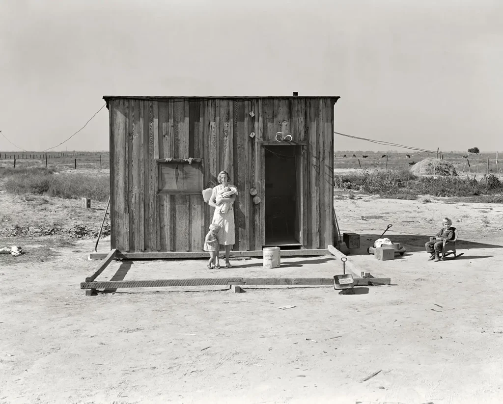 53.Una madre con i suoi figli piccoli vive in una baracca di legno in mezzo ai campi. 1930s