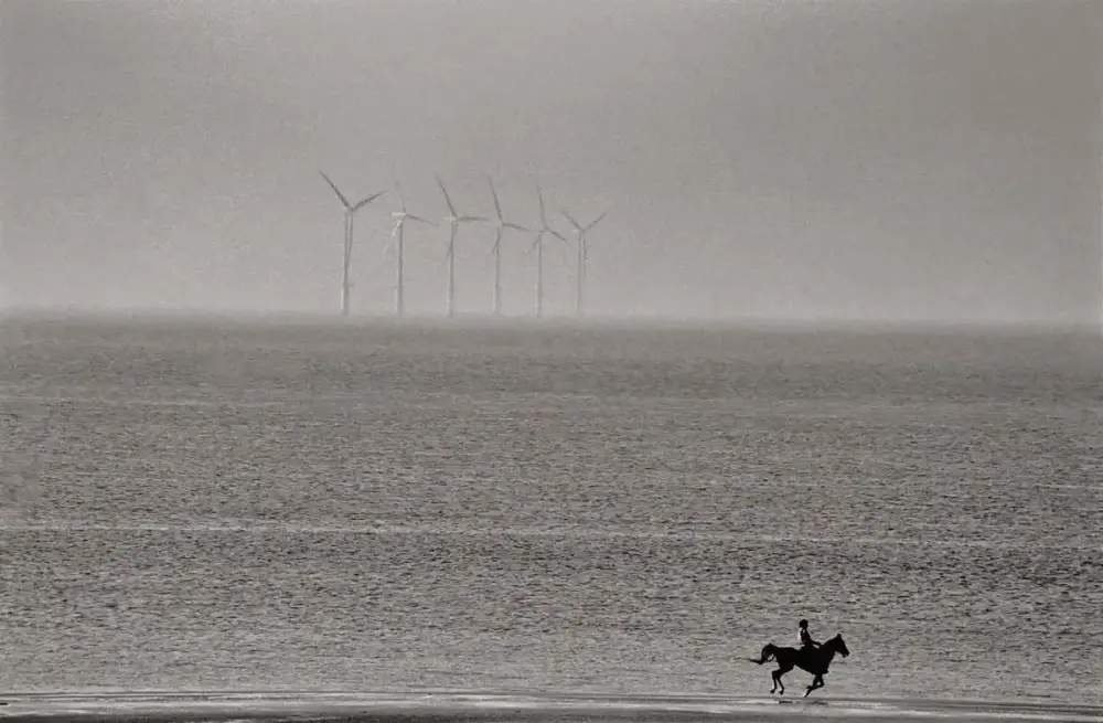 66.Un uomo galoppa con il suo cavallo lungo la spiaggia vicino a Prestatyn Galles Regno Unito