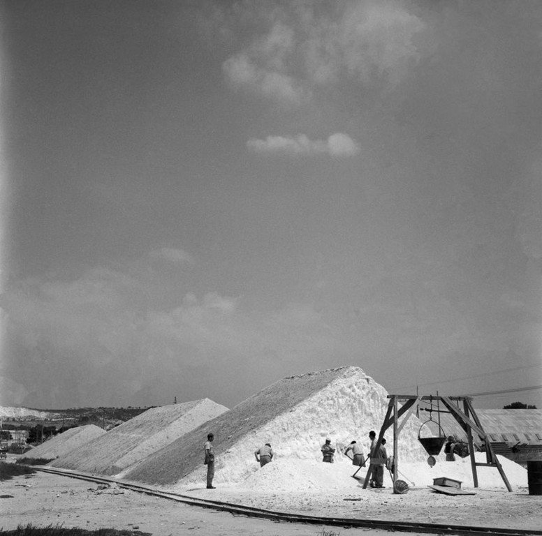 20.Scena di lavoro in una salina di Cagliari con grandi mucchi di sale bianco saline e operai impegnati nella raccolta. Sardegna 1956. Jean Dieuzaide