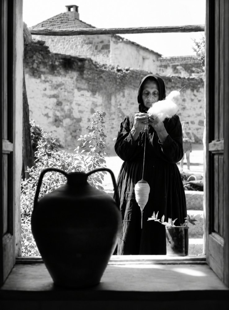 57.Donna anziana vestita di nero che fila la lana con un fuso. Fonni Sardegna 1956. Foto Jean Dieuzaide