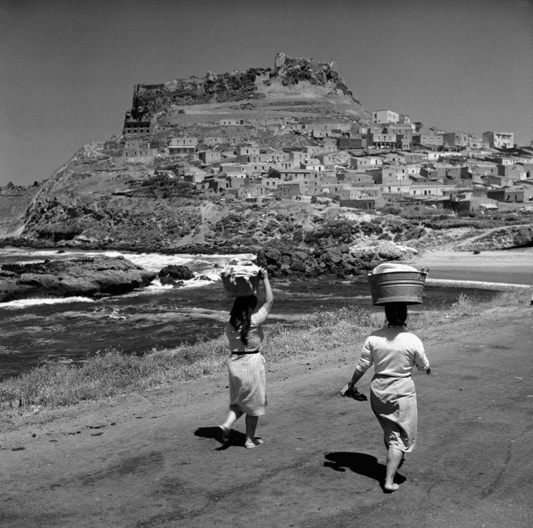 8.Due donne camminano lungo la strada vicino al mare. Castelsardo giugno del 1956 .Sardegna 1956. Jean Dieuzaide