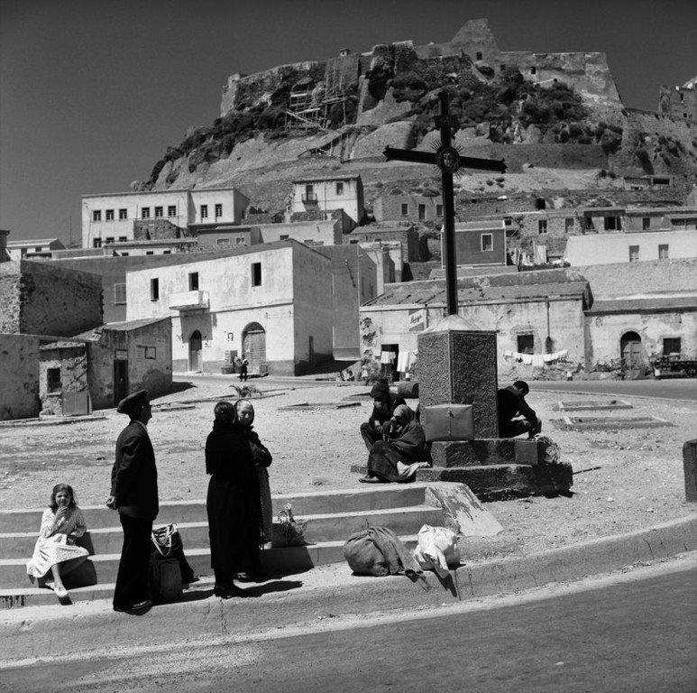 9.Castelsardo un gruppo di viaggiatori attende la corriera giugno 1956. Sardegna Jean Dieuzaide